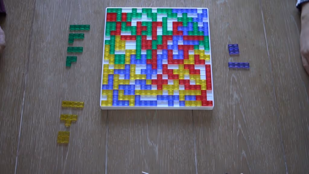Blokus board game with green, purple, red, and yellow pieces almost filling the board.