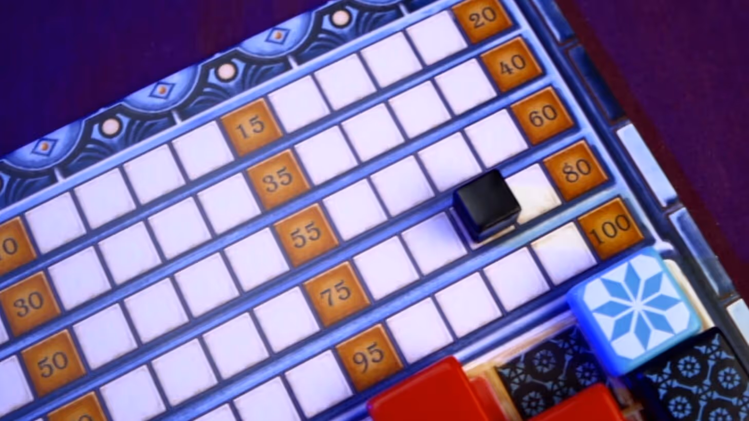 Close-up of Azul board game scoring track, featuring player markers and colorful tiles placed on the board
